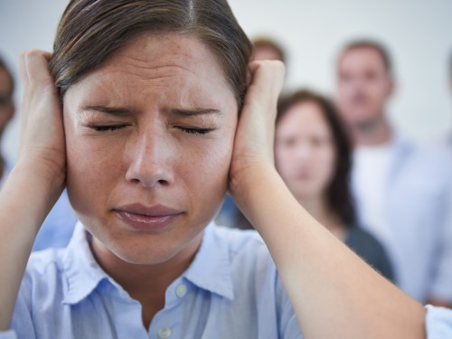 Das ist zu viel. Aufnahme einer gestressten jungen Frau, die versucht, sich von der Welt abzuschotten.